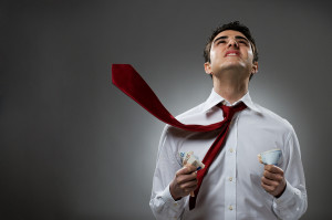 Young businessman pray with blowing necktie and bunch of money.