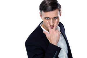 Confident businessman making "watching you" gesture