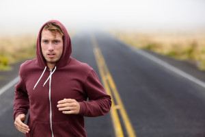 Athlete man running training on road in fall in sweatshirt hoodi