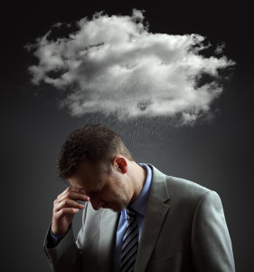 Stress, depression and despair - gloomy storm cloud raining above a businesmans head