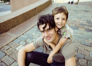 little son with father in city hagging and smiling, casual look outside playing