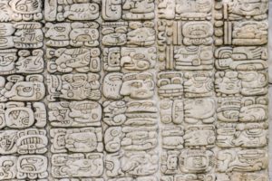Mayan hieroglyphics carved in a stone facade (replica).