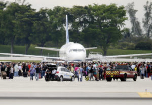 People stand on the tarmac at the Fort Lauderdale-Hollywood International Airport after a shooter opened fire inside a terminal of the airport, killing several people and wounding others before being taken into custody in Fort Lauderdale, Fla., on Friday.