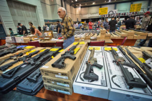 December 16th, Larry, The owner of Larry Guns behind a display of AR 15's and AK 47s, says he is selling his high ticket value guns better then ever at the gun show in the Pontchartrain Center in Kenner, Louisiana held by Great Southern Gun and Knife Shows L.L. C. . Gun sales have increased since the school shooting massacre in Sandy Hook Connecticut, especially AR 15s, one of the types of guns used by shooter Adam Lanza, as gun owners fear new legislature will soon regulate sales of such guns.