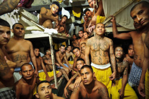 Members of a gang known as the Mara 18 crowd into cells at the Izalco jail in Sonsonate, El Salvador. A Honduran fire and a Mexican massacre have drawn new attention to deteriorating conditions at prisons in Latin America, many of which are stuffed over capacity, leaving inmates to string hammocks from the ceiling or bed down on the floor. (Meridith Kohut/The New York Times)